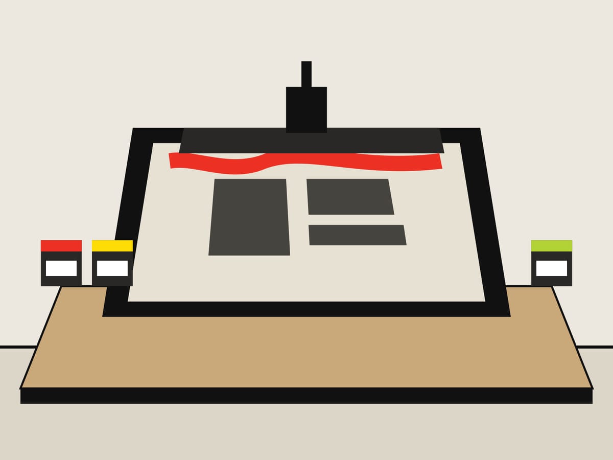 Telaio serigrafico sul banco con l’inchiostro rosso e la racla pronta per la passata